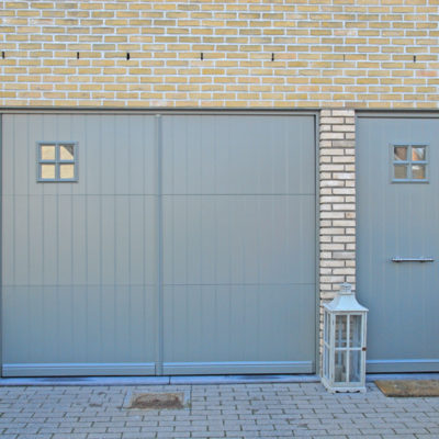 Pastorie sectionaalpoort in aluminium kaders met aluminium opdekpanelen en Presence pastorie voordeur met vierkant raam