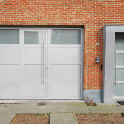 Kantelpoort in aluminium met ingewerkte loopdeur en bijhorende voordeur